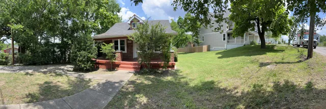 a view of a house with a yard and tree s