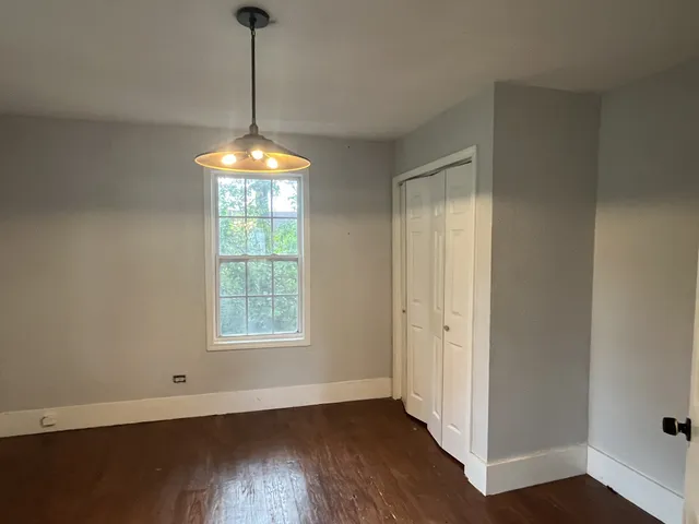a an empty room with wooden floor and windows