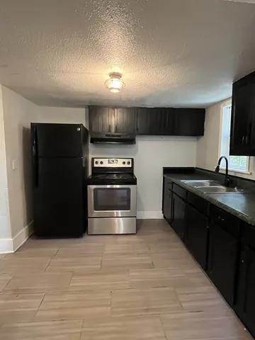 a kitchen with stainless steel appliances granite countertop a refrigerator and a stove