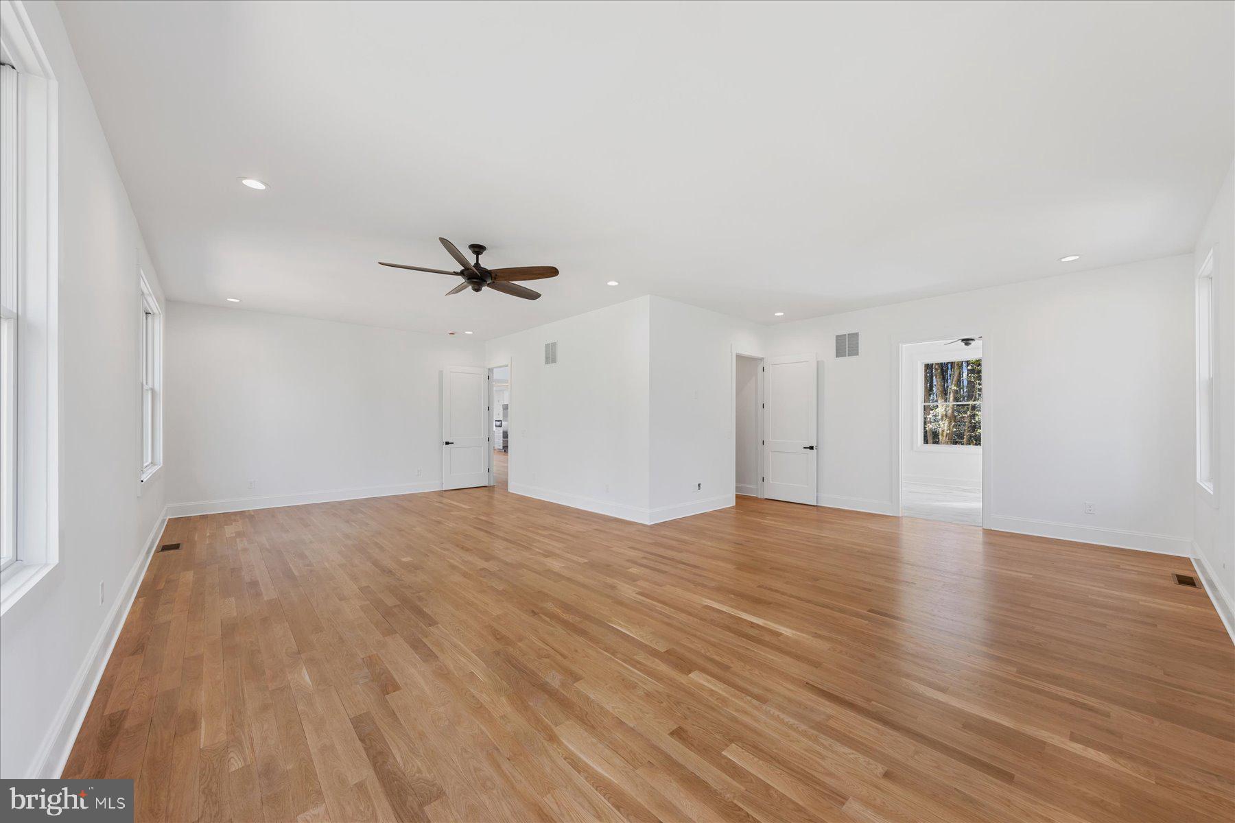 30425 Hollymount Road Harbeson, DE 19951 - Photo 38 of 98 an empty room with wooden floor a ceiling fan and windows