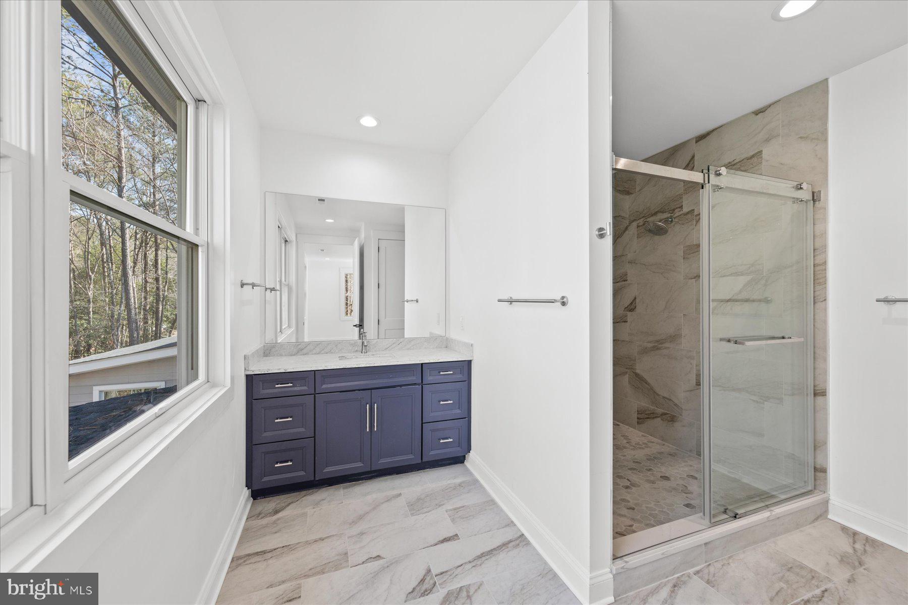 30425 Hollymount Road Harbeson, DE 19951 - Photo 53 of 98 a bathroom with a glass door shower a sink and a mirror