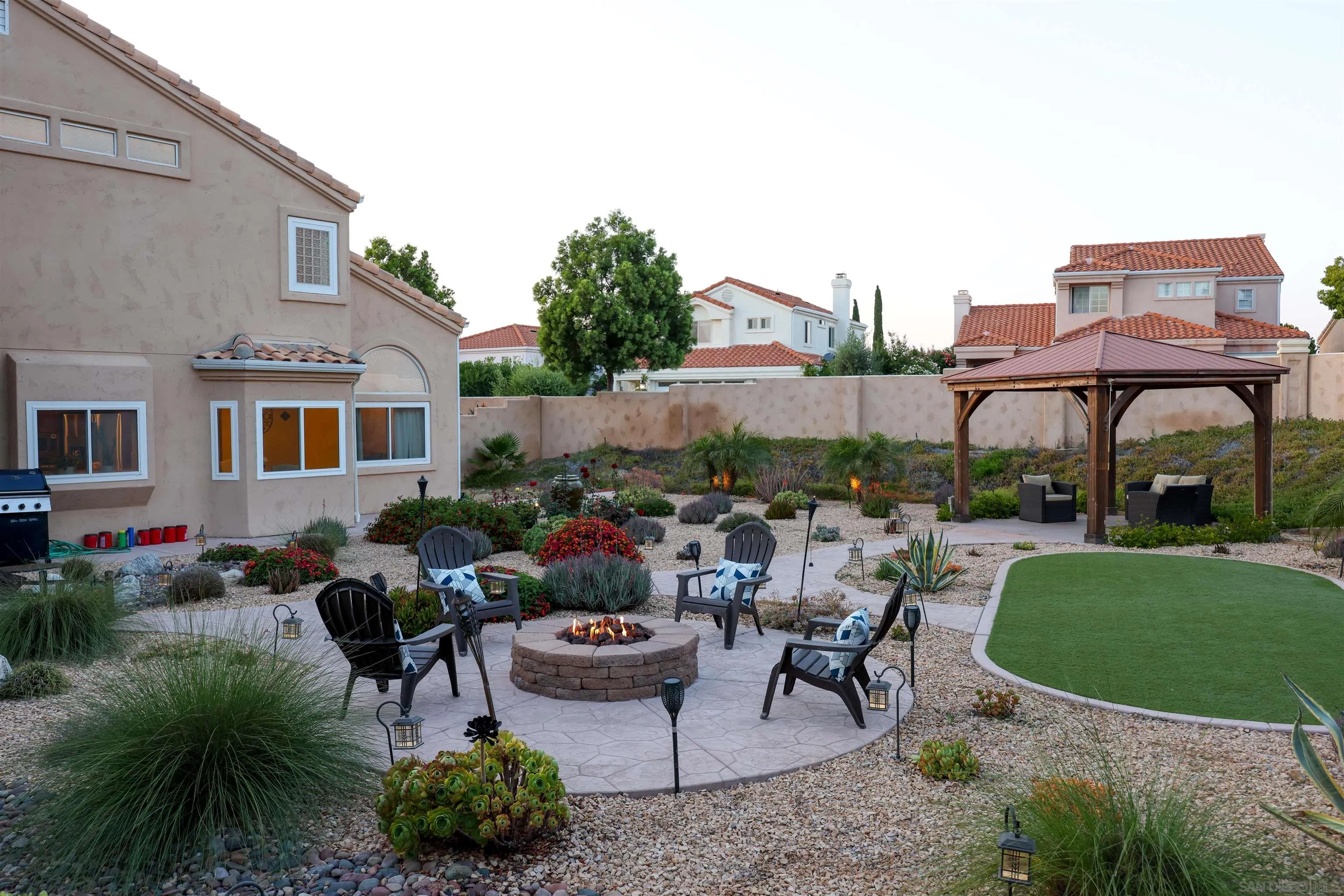2 Bella Minozza Lake Elsinore, CA 92532 - Photo 25 of 30 a view of a patio with table and chairs potted plants and a large tree
