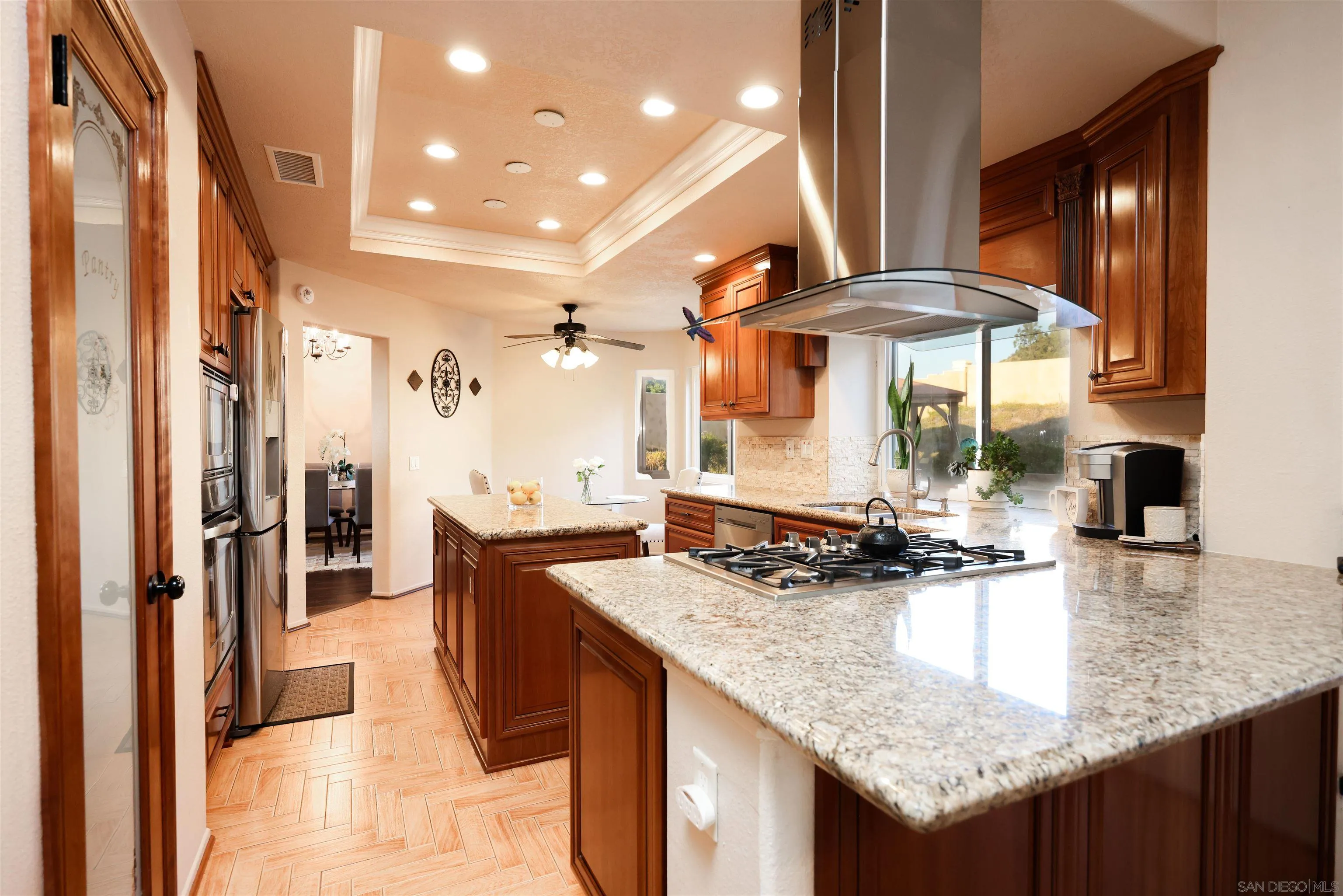 2 Bella Minozza Lake Elsinore, CA 92532 - Photo 9 of 30 a kitchen with stainless steel appliances granite countertop a table chairs and a refrigerator