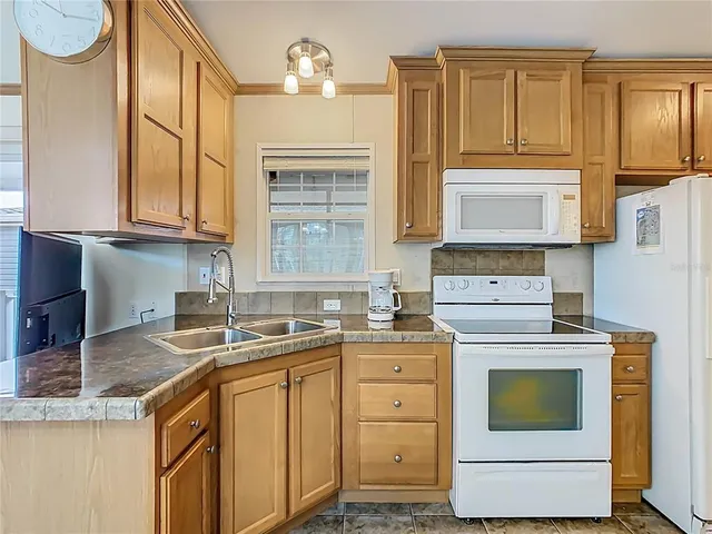 a kitchen with granite countertop a sink stove and cabinets