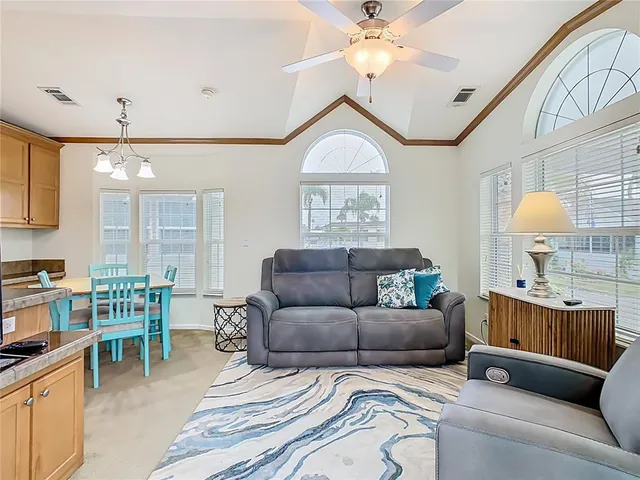 a living room with furniture a chandelier and a window