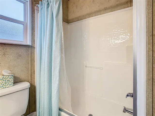 a bathroom with a toilet and a shower