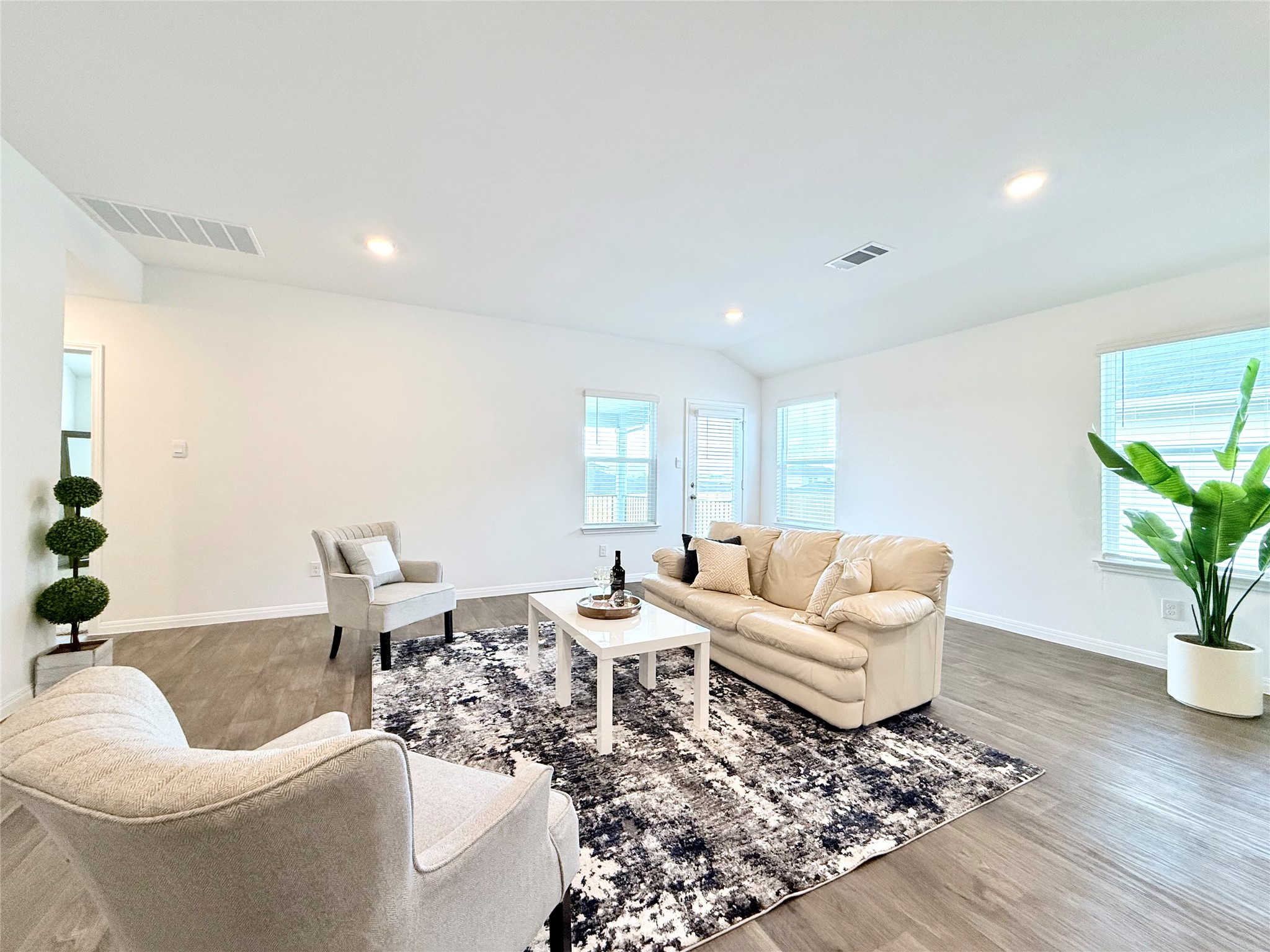 598 Gladiola Loop Kyle, TX 78640 - Photo 11 of 33 Living room featuring wood finished floors, recessed lighting, and vaulted ceiling