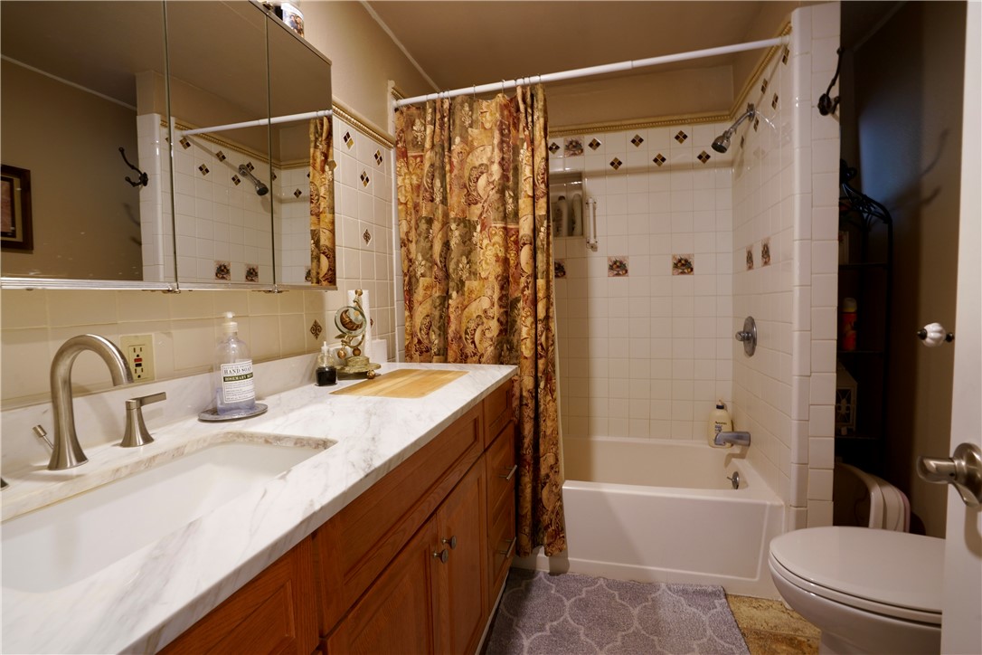 7296 Ligurta Road Golden Valley, AZ 86413 - Photo 24 of 49 a bathroom with a granite countertop sink toilet and shower
