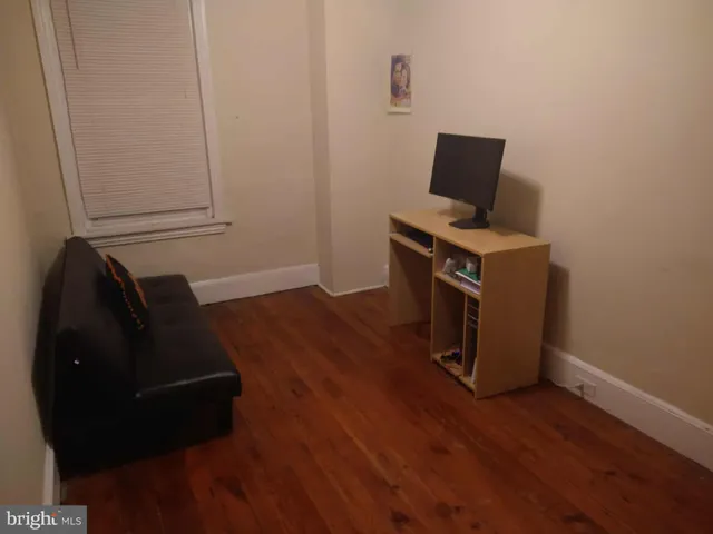a living room with wooden floor and a window