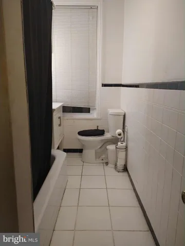 a bathroom with a granite countertop toilet and a sink