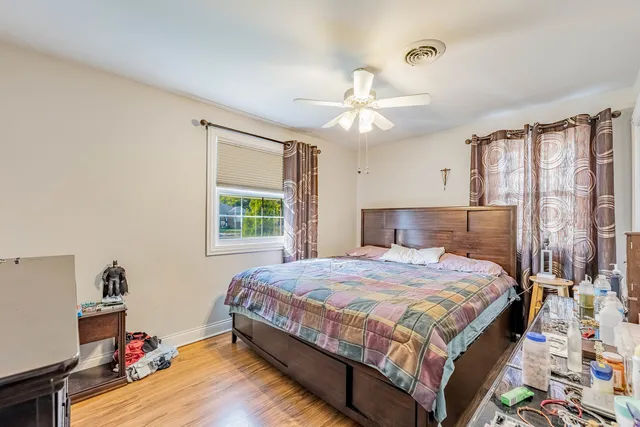 a bedroom with a bed chandelier and a window