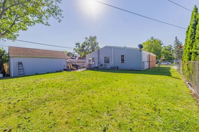 a view of a house with a big yard potted plants and large tree