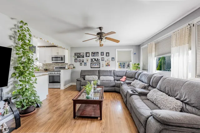 a living room with furniture ceiling fan and a window