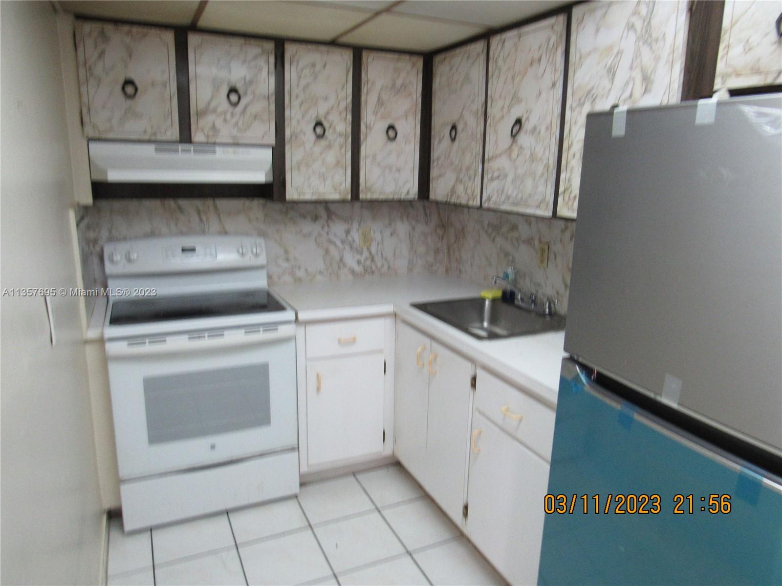 Flagami Miami, FL 33126 - Photo 6 of 12 a kitchen with stainless steel appliances white cabinets and a stove