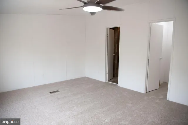 an empty room with a chandelier fan