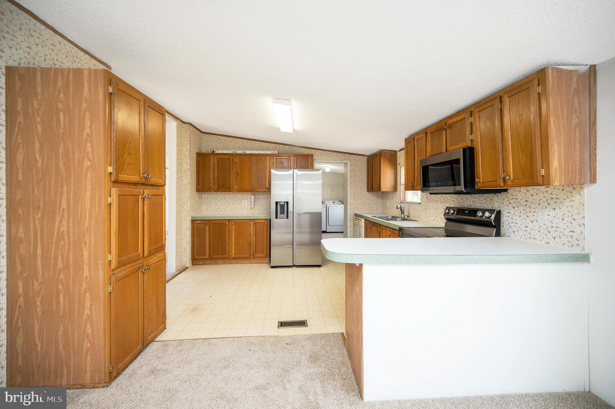 8705 Alsop Town Road Spotsylvania, VA 22551 - Photo 15 of 33 a large kitchen with stainless steel appliances granite countertop a refrigerator a stove top oven a sink and dishwasher