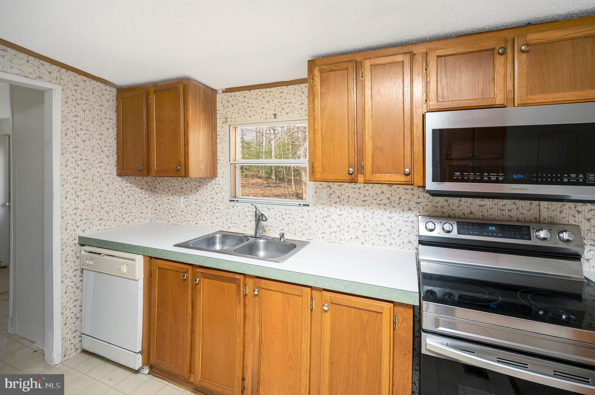8705 Alsop Town Road Spotsylvania, VA 22551 - Photo 19 of 33 a kitchen with stainless steel appliances a stove sink microwave and cabinets