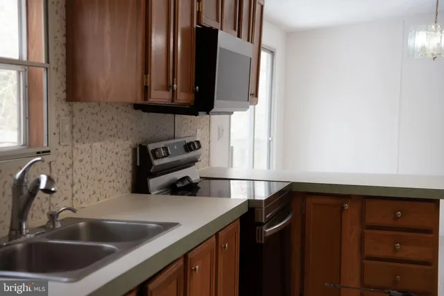 a kitchen with granite countertop a sink a stove and cabinets
