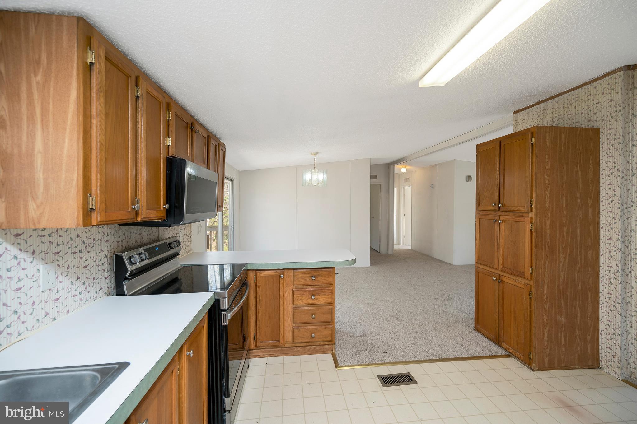 8705 Alsop Town Road Spotsylvania, VA 22551 - Photo 21 of 33 a kitchen with stainless steel appliances granite countertop a refrigerator a stove and a sink with wooden cabinets
