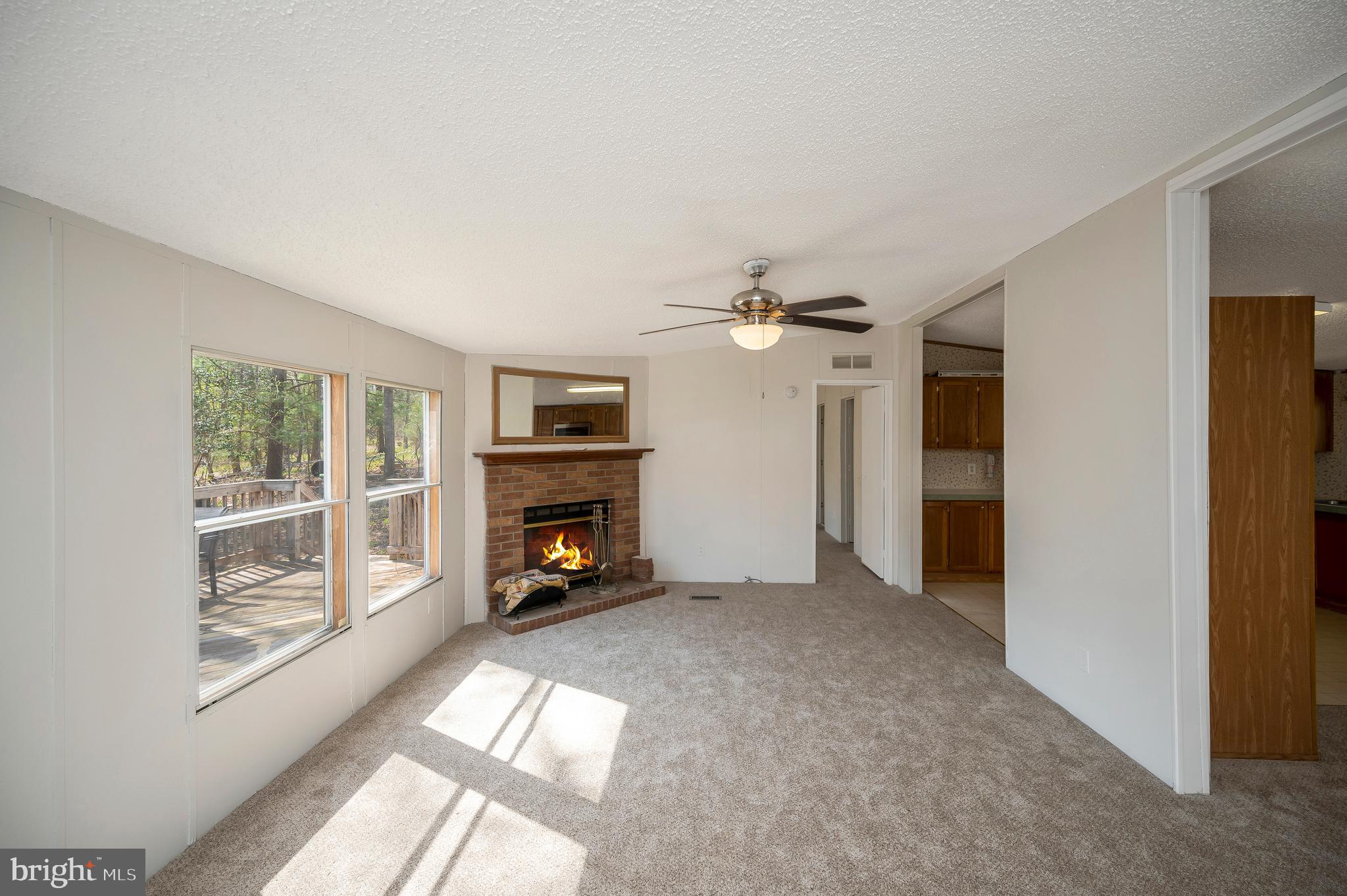 8705 Alsop Town Road Spotsylvania, VA 22551 - Photo 9 of 33 an empty room with windows fireplace and fans