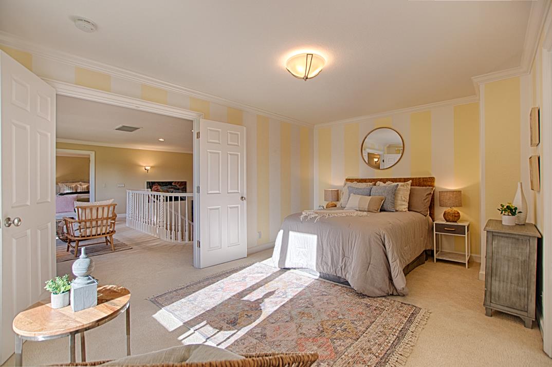 2140 Winged Foot Road Half Moon Bay, CA 94019 - Photo 26 of 52 a bedroom with a bed and chandelier