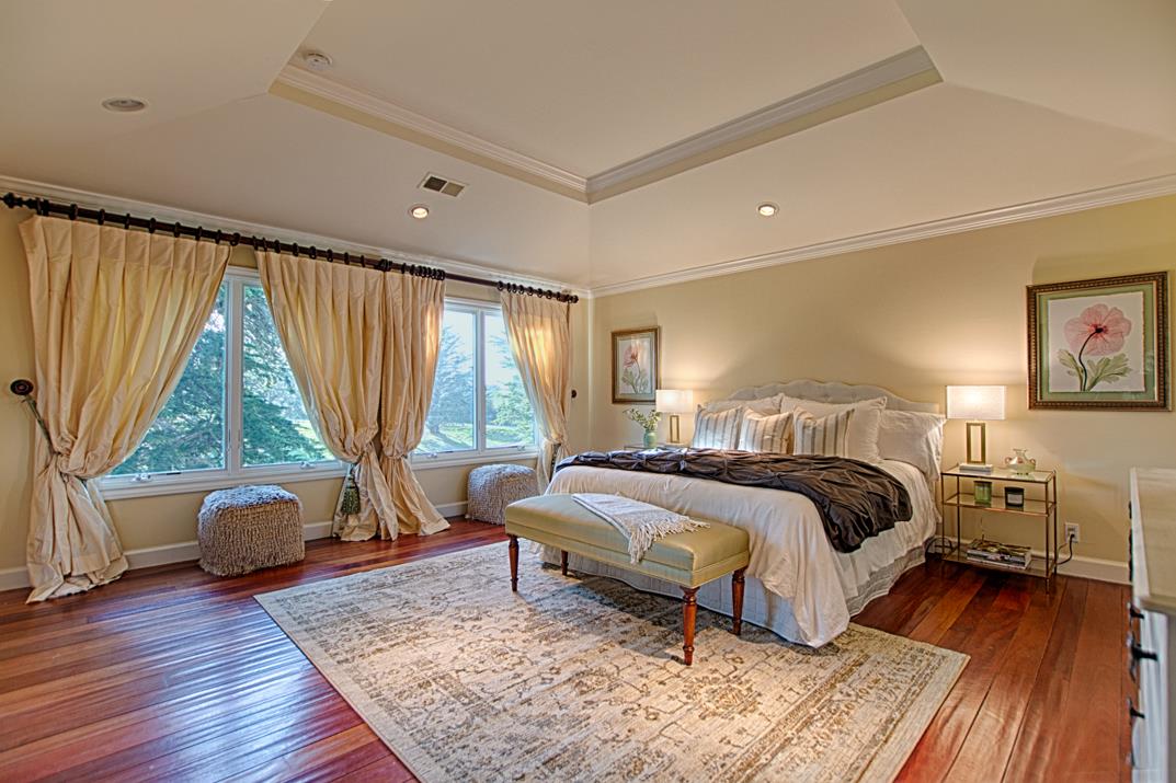 2140 Winged Foot Road Half Moon Bay, CA 94019 - Photo 33 of 52 a spacious bedroom with a bed and wooden floor