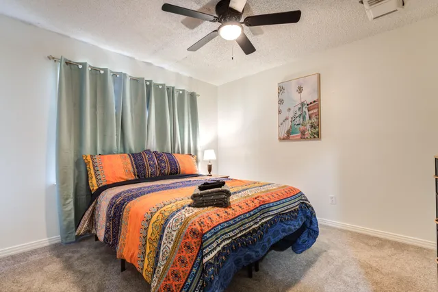 a bedroom with bed and paintings on the wall