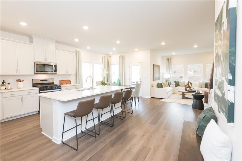 3940 Ladiga Street Powder Springs, GA 30127 - Photo 4 of 31 a kitchen with a sink a counter top space a center island stainless steel appliances and cabinets