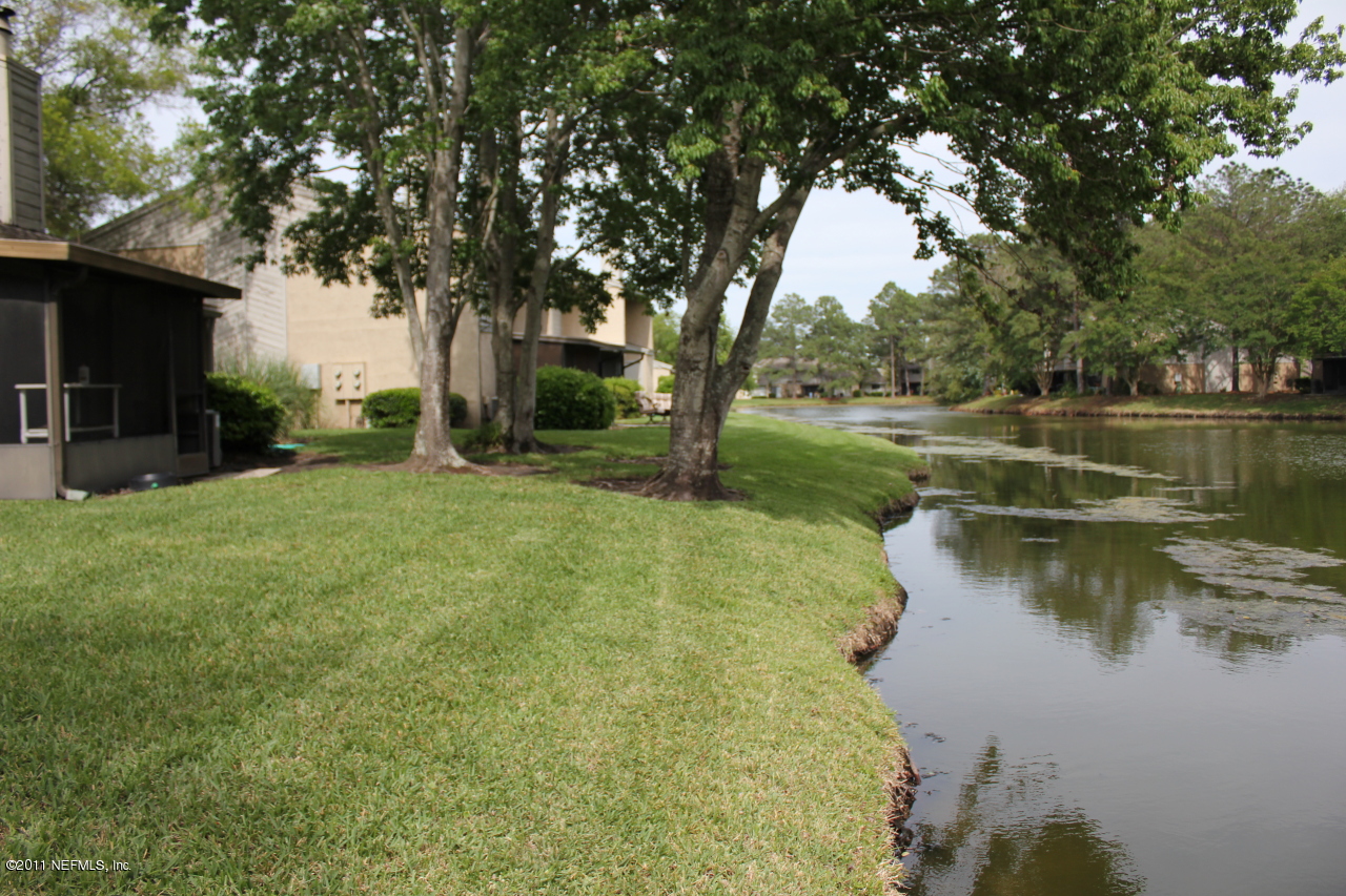 3801 Crown Point Road, Unit 2131 Jacksonville, FL 32257 - Photo 2 of 5 a view of a lake with a yard and large trees