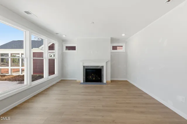 a view of an empty room with a window and fireplace