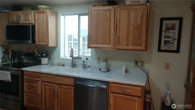 a kitchen with stainless steel appliances granite countertop a sink a stove and a microwave