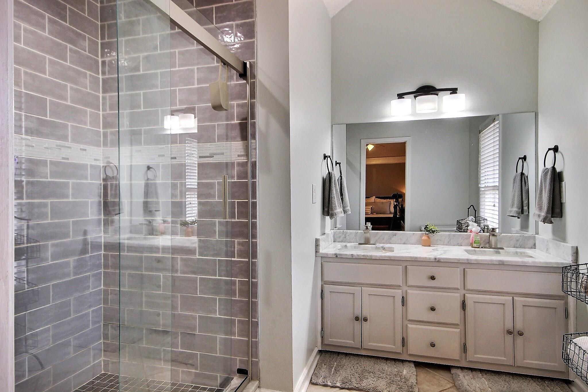 556 Rillbrook Drive Collierville, TN 38017 - Photo 13 of 22 a bathroom with a double vanity sink a mirror and a shower