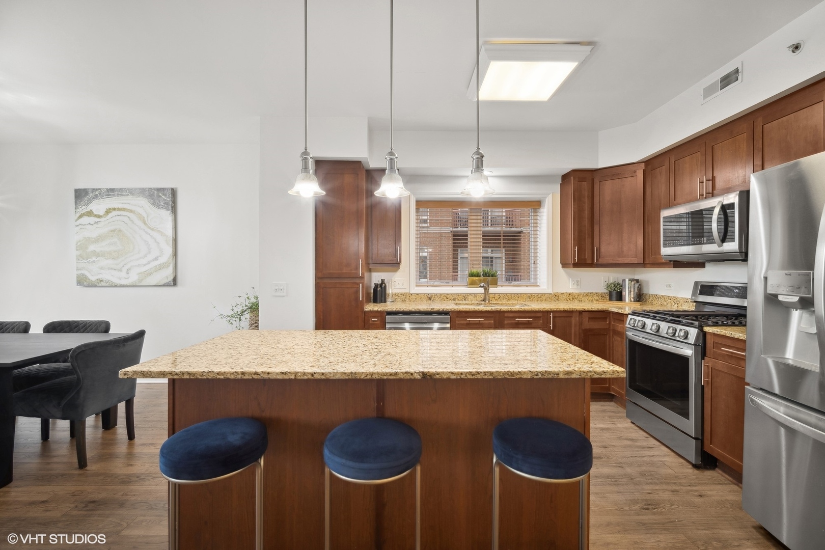 799 Graceland Avenue, Unit 502A Des Plaines, IL 60016 - Photo 12 of 31 a large kitchen with kitchen island a stove a sink a dining table and chairs
