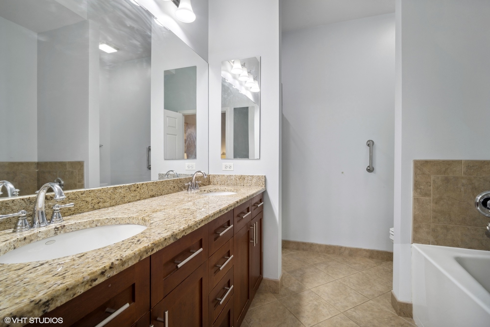 799 Graceland Avenue, Unit 502A Des Plaines, IL 60016 - Photo 24 of 31 a bathroom with a granite countertop sink a large mirror and a bathtub