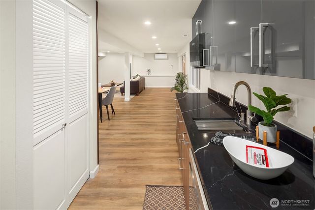 a large kitchen with kitchen island a large counter top space a sink wooden floor and stainless steel appliances