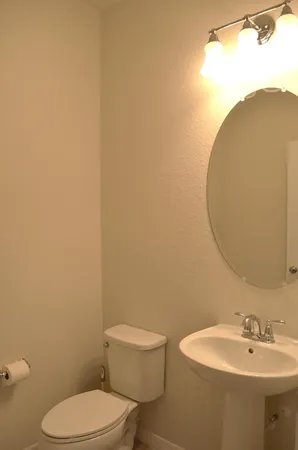 a bathroom with a toilet a sink and mirror