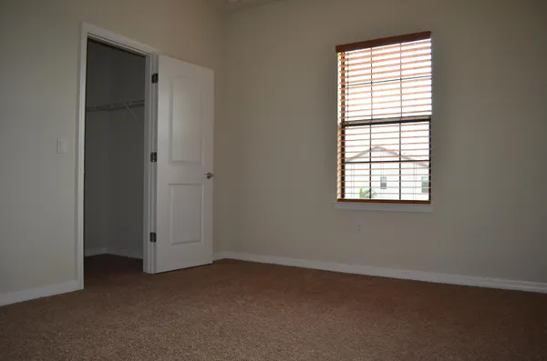 an empty room with windows and closet
