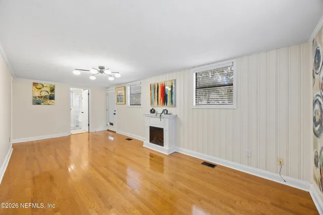 a view of a hallway with wooden floor and closet area