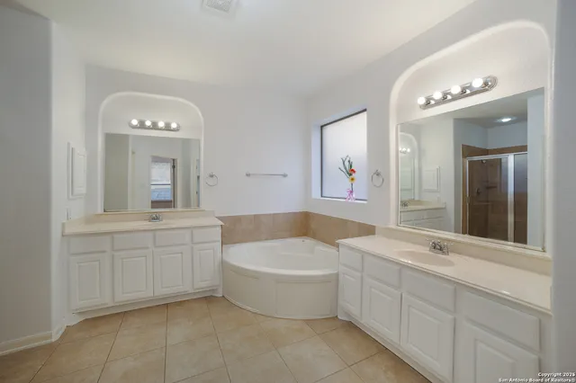 a bathroom with a tub a sink and mirror