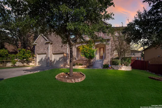 a front view of a house with a garden and trees