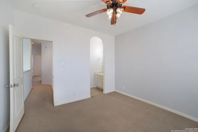 an empty room with a chandelier and a chandelier fan