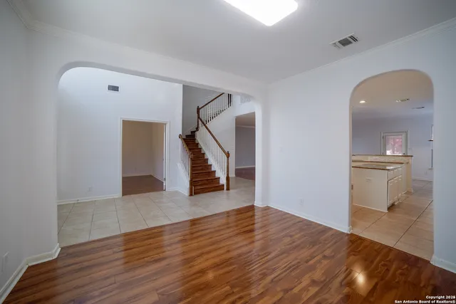 a view of empty room with wooden floor