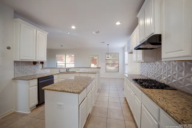 a kitchen with stainless steel appliances granite countertop a sink stove and cabinets