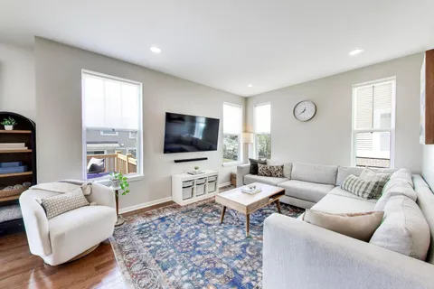 a living room with furniture a flat screen tv and a large window