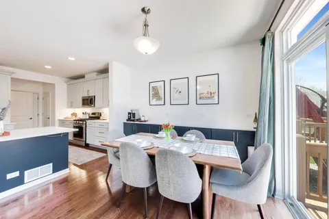 a living room with furniture kitchen view and a large window