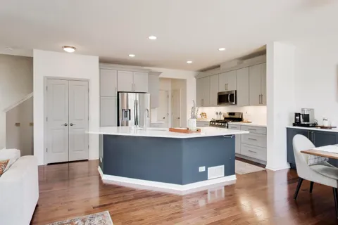 a kitchen with stainless steel appliances a sink cabinets and wooden floor