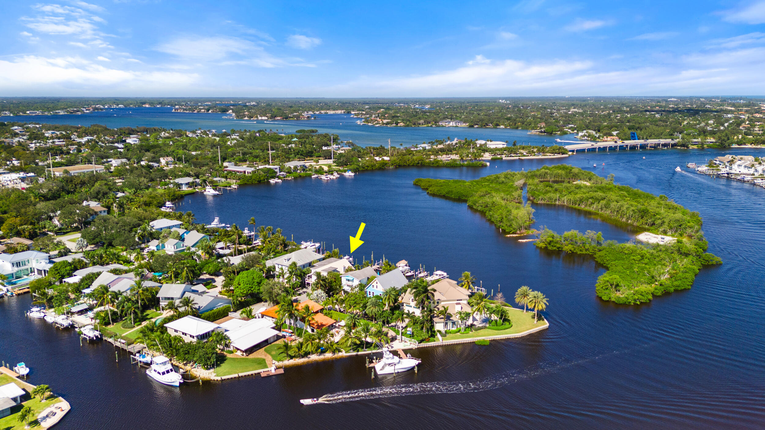 an aerial view of water body with boats and residential houses with outdoor space