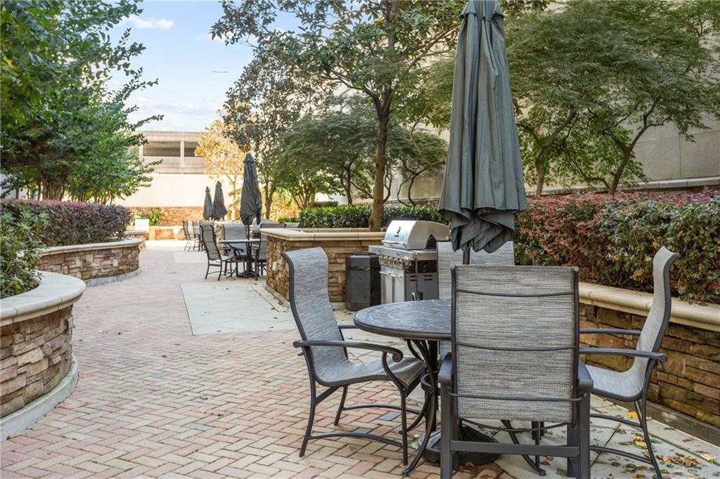 3040 Peachtree Road, Unit 1205 Atlanta, GA 30305 - Photo 25 of 43 a view of a patio with table and chairs and potted plants