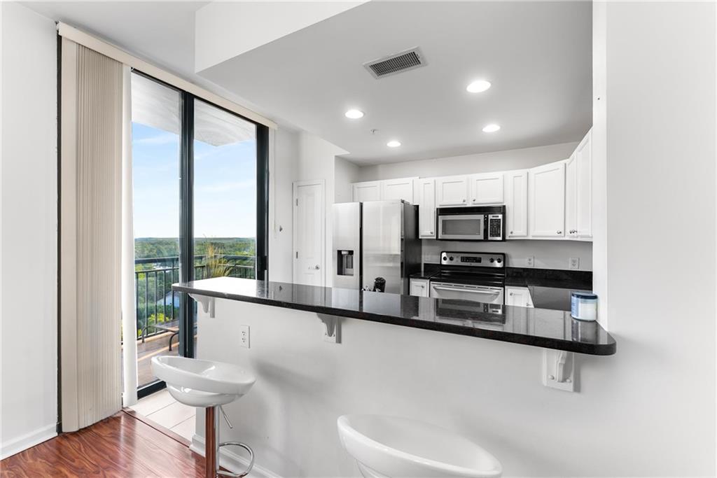 3040 Peachtree Road, Unit 1205 Atlanta, GA 30305 - Photo 3 of 43 a large white kitchen with a large window and stainless steel appliances