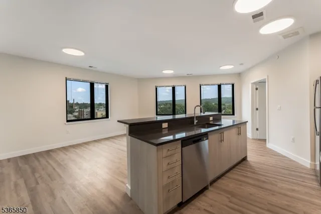a kitchen with stainless steel appliances granite countertop a sink and wooden floors